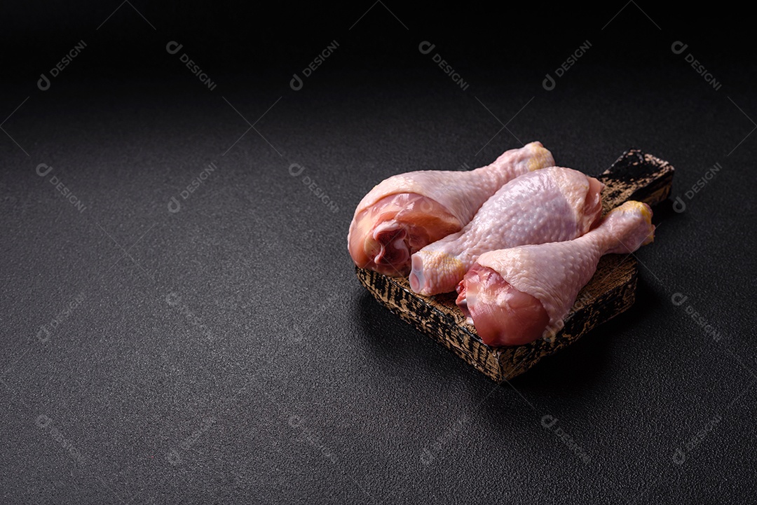 A imagem mostra sobrecoxas de frango cruas em um prato.