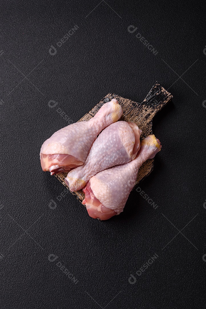 Imagem de pedaços de frango cru em uma tábua de madeira
