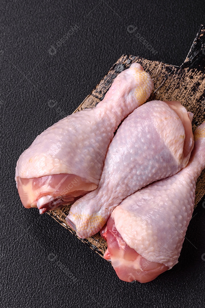 Imagem de pedaços de frango cru em uma tábua de madeira