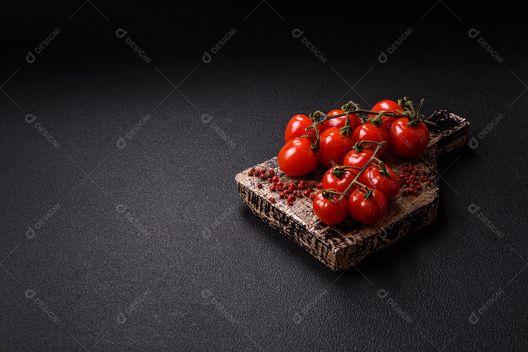 A imagem mostra tomates cereja em rama, acompanhados de pimenta rosa em grãos, sal rosa do Himalaia e açafrão em pó