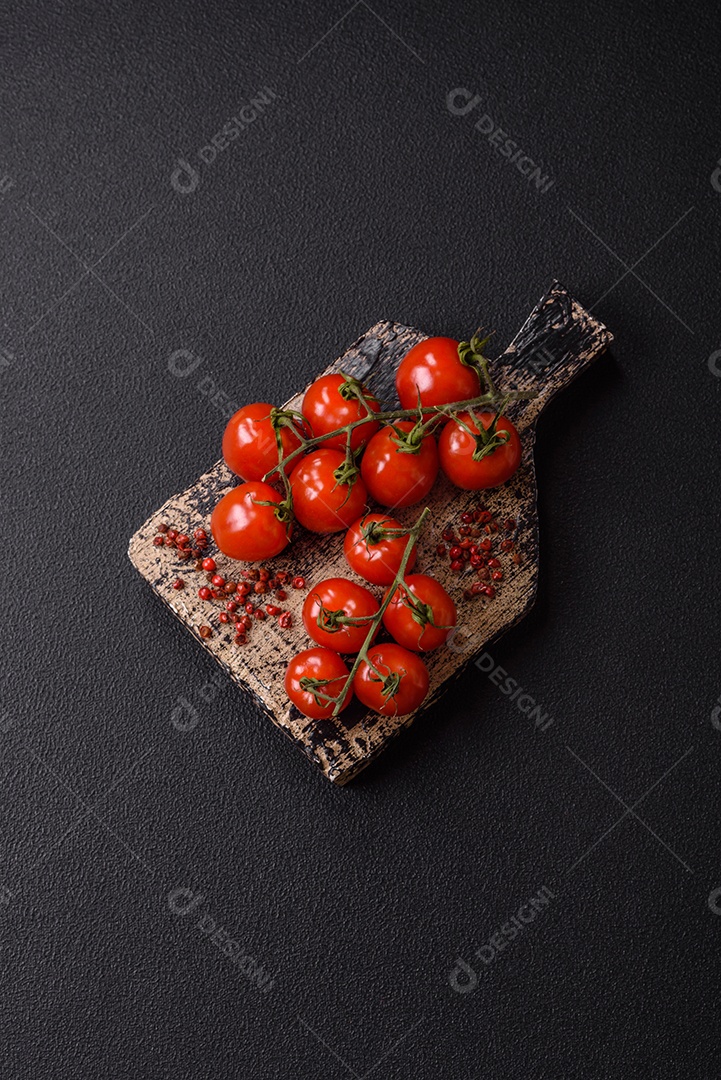 A imagem mostra tomates cereja em rama, acompanhados de pimenta rosa em grãos, sal rosa do Himalaia e açafrão em pó
