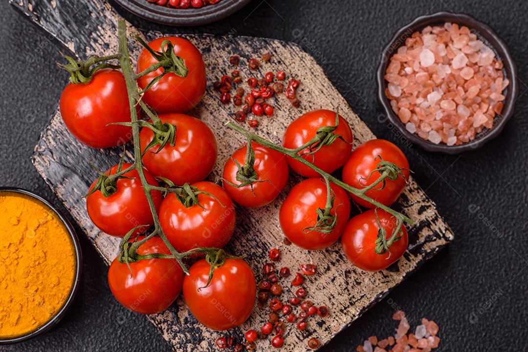 A imagem mostra tomates cereja em rama, acompanhados de pimenta rosa em grãos, sal rosa do Himalaia e açafrão em pó