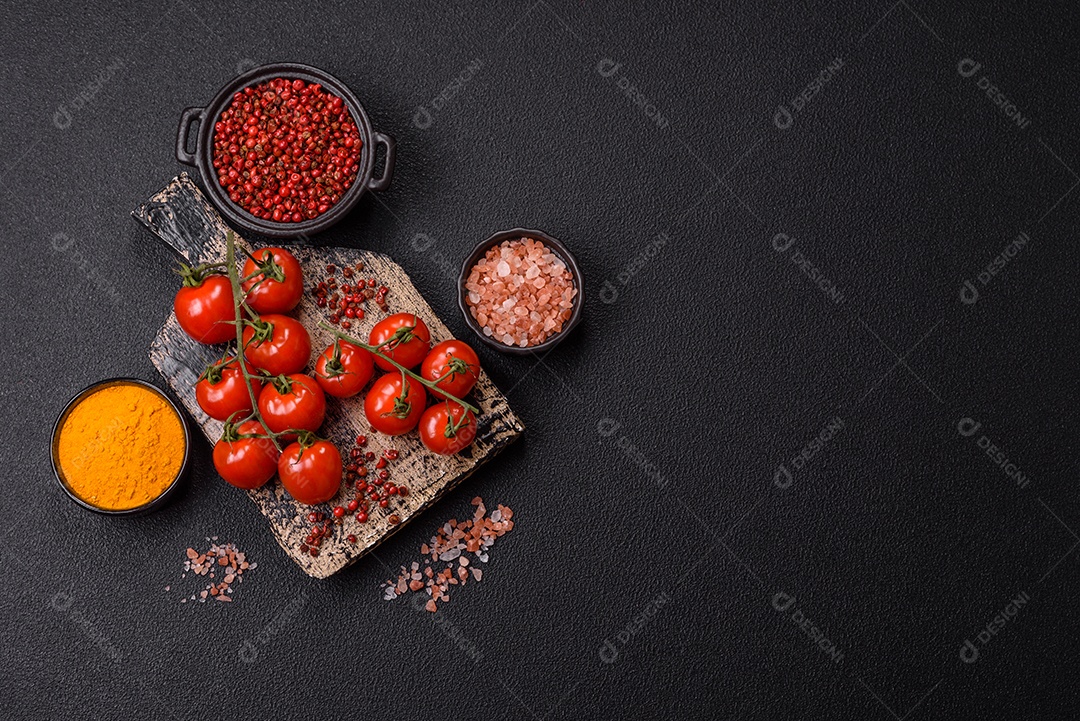 A imagem mostra tomates cereja em rama, acompanhados de pimenta rosa em grãos, sal rosa do Himalaia e açafrão em pó