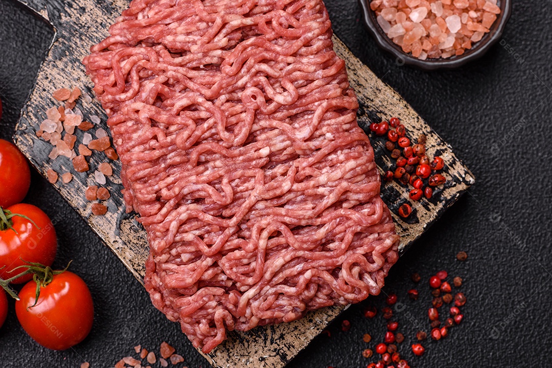 Imagem mostra ingredientes para uma receita, incluindo carne moída, tomates cereja, pimentas vermelhas e sal grosso