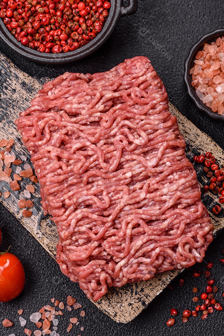 Imagem mostra ingredientes para uma receita, incluindo carne moída, tomates cereja, pimentas vermelhas e sal grosso