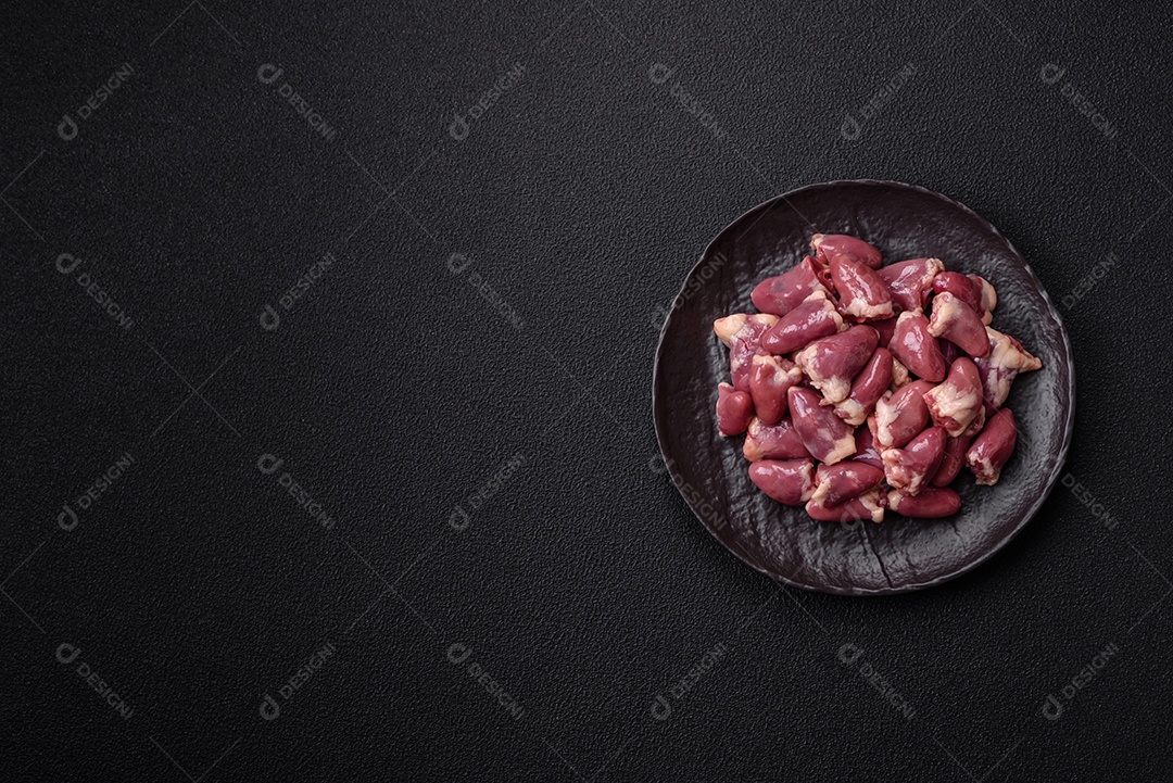 A imagem mostra corações de frango crus em uma tábua de madeira, acompanhados de pimenta rosa e tomates-cereja.