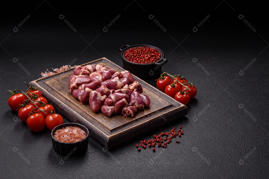 A imagem mostra corações de frango crus em uma tábua de madeira, acompanhados de pimenta rosa e tomates-cereja.
