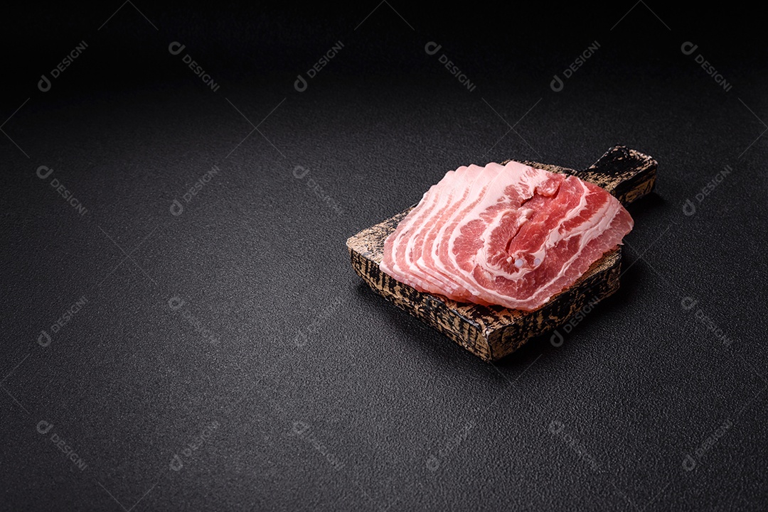 A imagem mostra fatias de barriga de porco crua, também conhecida como toucinho ou, em alguns casos, bacon. A barriga de porco