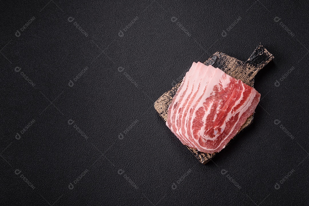 A imagem mostra fatias de barriga de porco crua, também conhecida como toucinho ou, em alguns casos, bacon. A barriga de porco