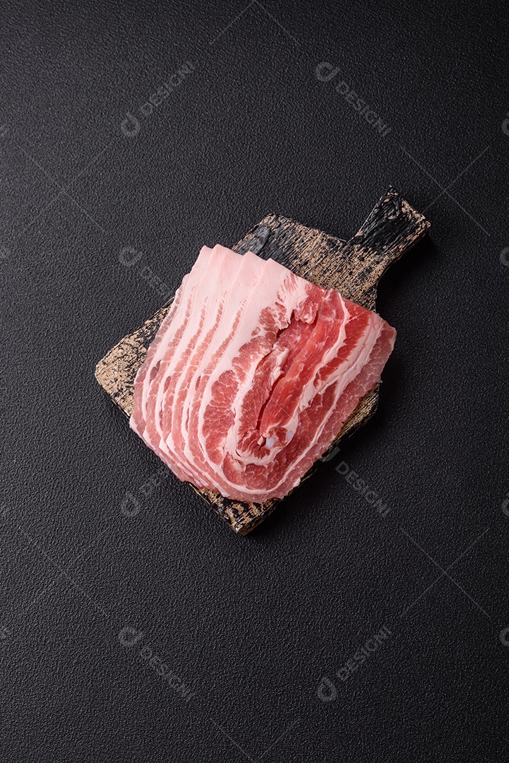 A imagem mostra fatias de barriga de porco crua, também conhecida como toucinho ou, em alguns casos, bacon. A barriga de porco