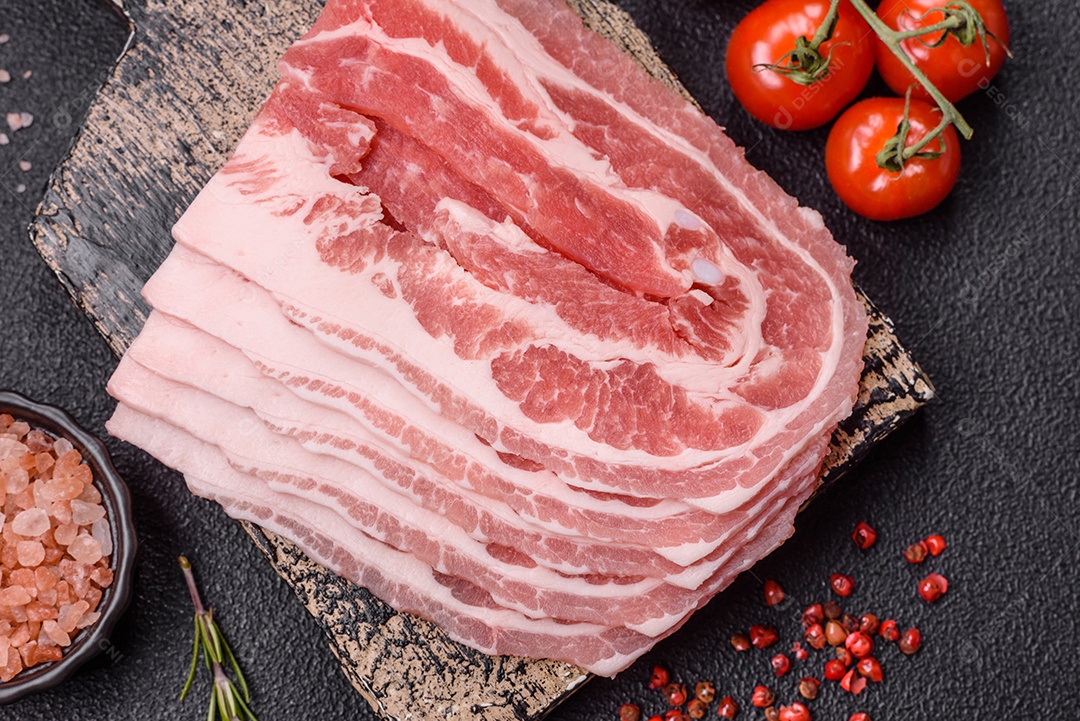 A imagem mostra fatias de barriga de porco crua, também conhecida como toucinho ou, em alguns casos, bacon. A barriga de porco