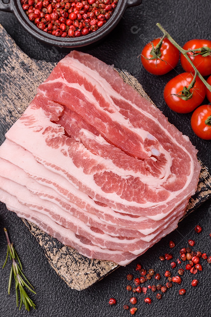 A imagem mostra fatias de barriga de porco crua, também conhecida como toucinho ou, em alguns casos, bacon. A barriga de porco