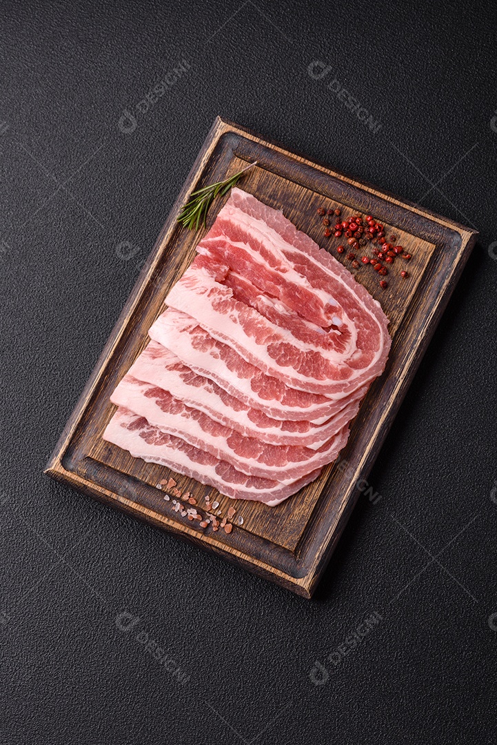 A imagem mostra fatias de barriga de porco crua, também conhecida como toucinho ou, em alguns casos, bacon. A barriga de porco