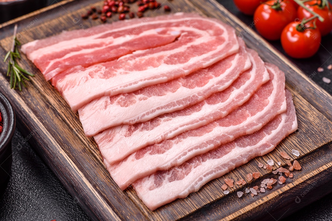 A imagem mostra fatias de barriga de porco crua, também conhecida como toucinho ou, em alguns casos, bacon. A barriga de porco