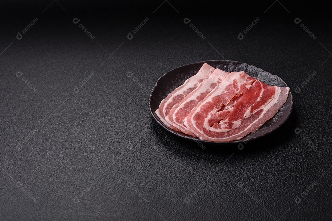 A imagem mostra fatias de barriga de porco crua, também conhecida como toucinho ou, em alguns casos, bacon. A barriga de porco