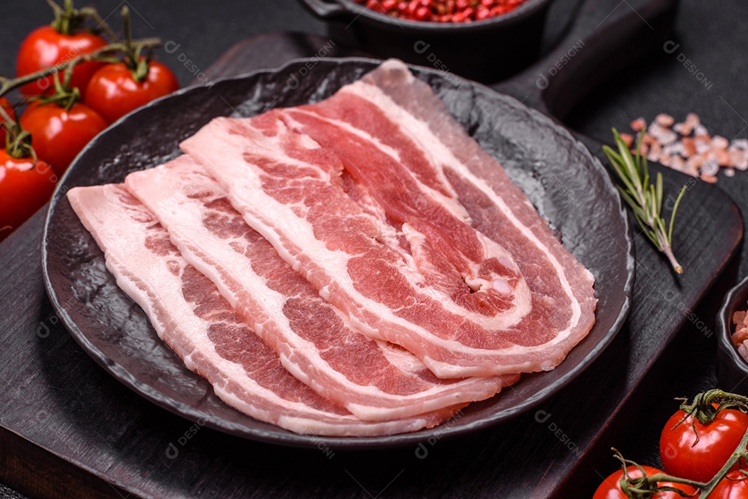 A imagem mostra fatias de barriga de porco crua, também conhecida como toucinho ou, em alguns casos, bacon. A barriga de porco