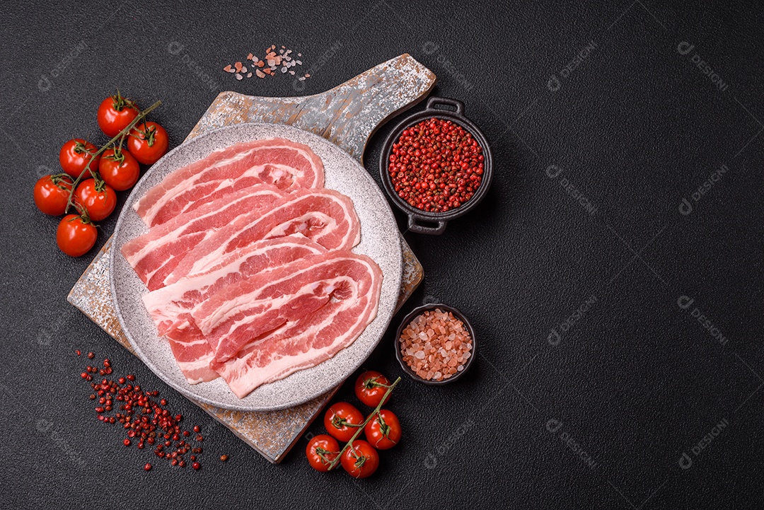 A imagem mostra fatias de barriga de porco crua, também conhecida como toucinho ou, em alguns casos, bacon. A barriga de porco