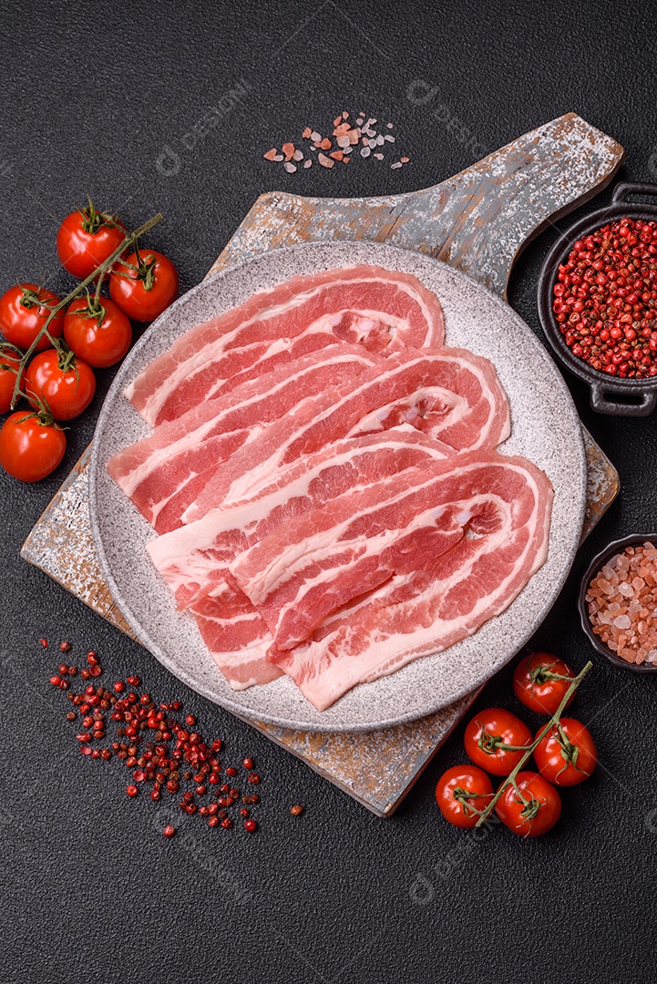 A imagem mostra fatias de barriga de porco crua, também conhecida como toucinho ou, em alguns casos, bacon. A barriga de porco