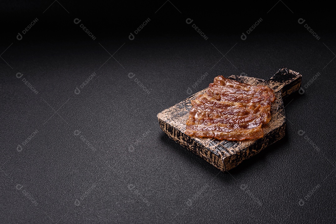 A imagem mostra toucinho frito em um prato, acompanhado de tomates-cereja e pimenta-rosa