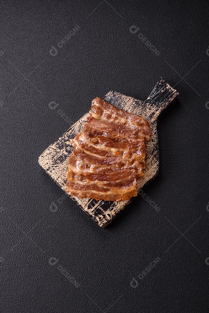 A imagem mostra toucinho frito em um prato, acompanhado de tomates-cereja e pimenta-rosa