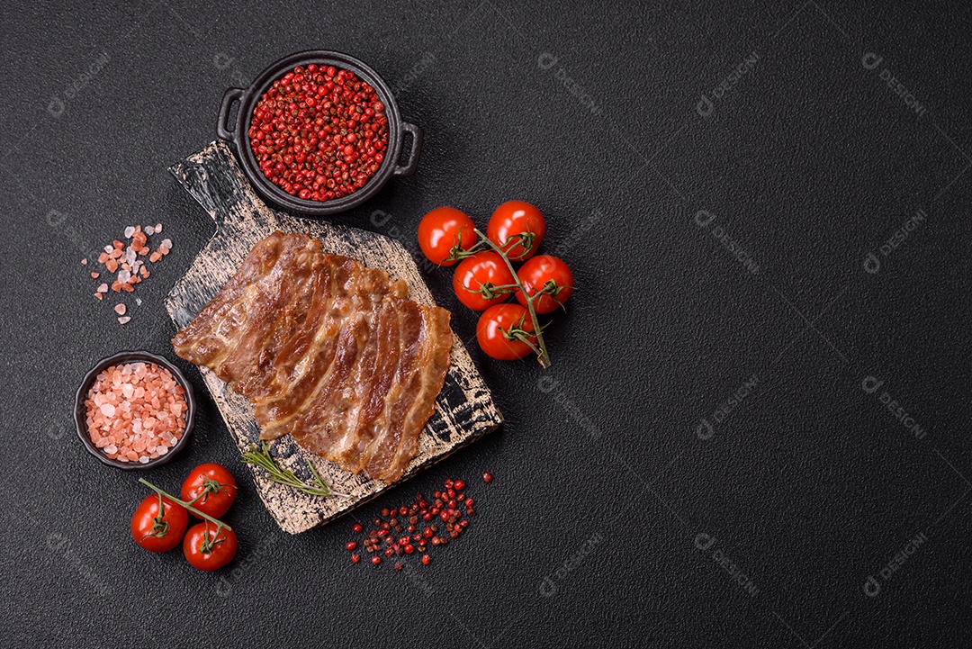 A imagem mostra toucinho frito em um prato, acompanhado de tomates-cereja e pimenta-rosa