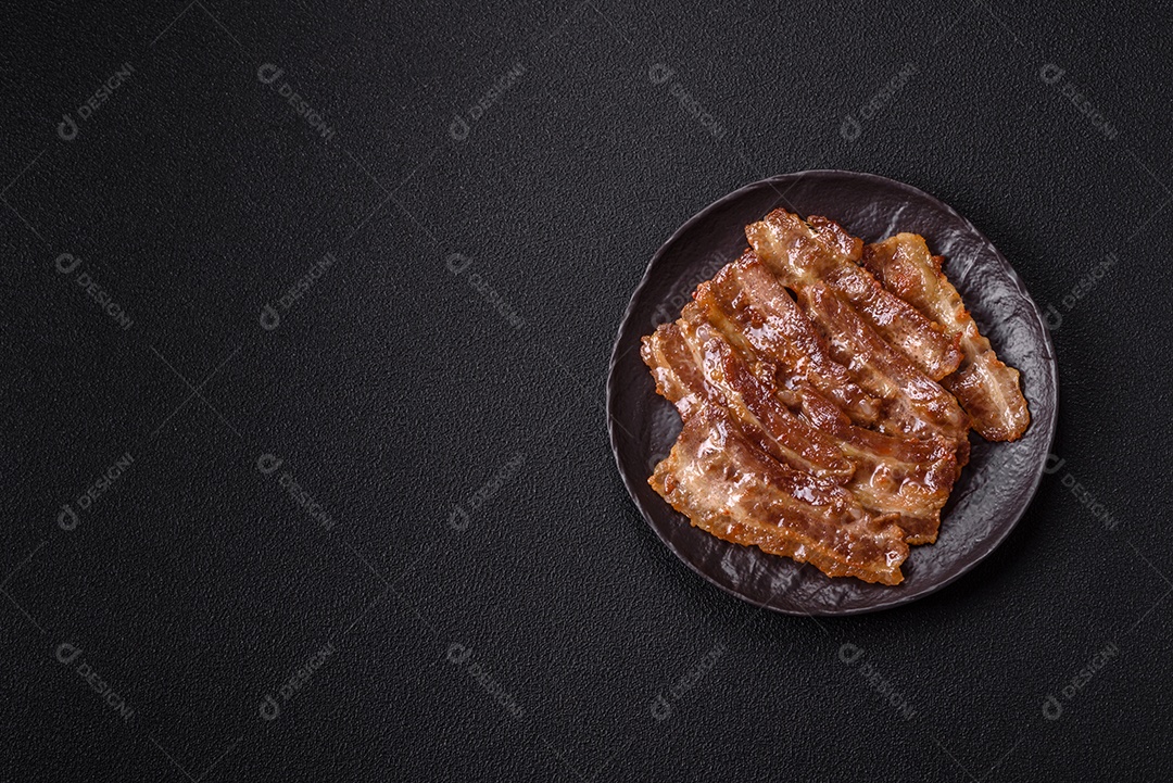 A imagem mostra toucinho frito em um prato, acompanhado de tomates-cereja e pimenta-rosa