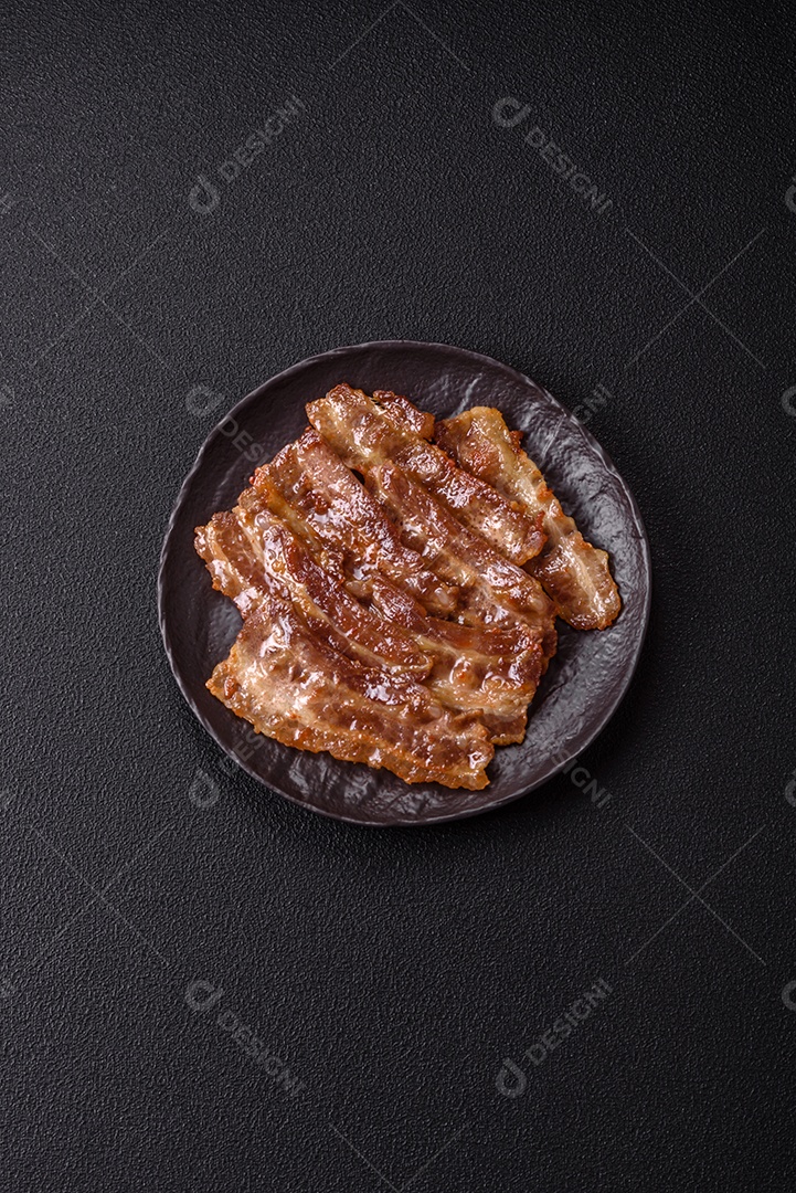 A imagem mostra toucinho frito em um prato, acompanhado de tomates-cereja e pimenta-rosa