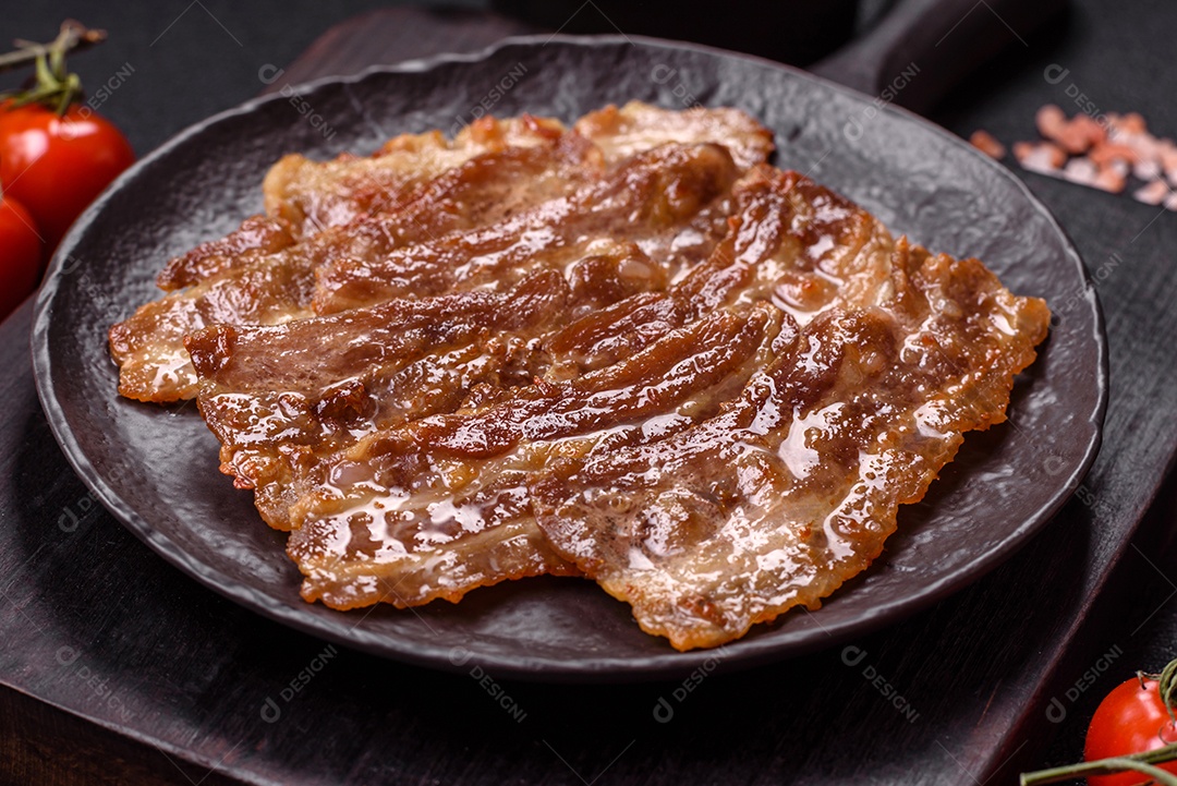 A imagem mostra toucinho frito em um prato, acompanhado de tomates-cereja e pimenta-rosa