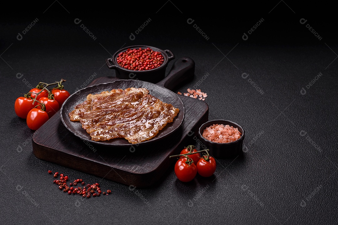 A imagem mostra toucinho frito em um prato, acompanhado de tomates-cereja e pimenta-rosa