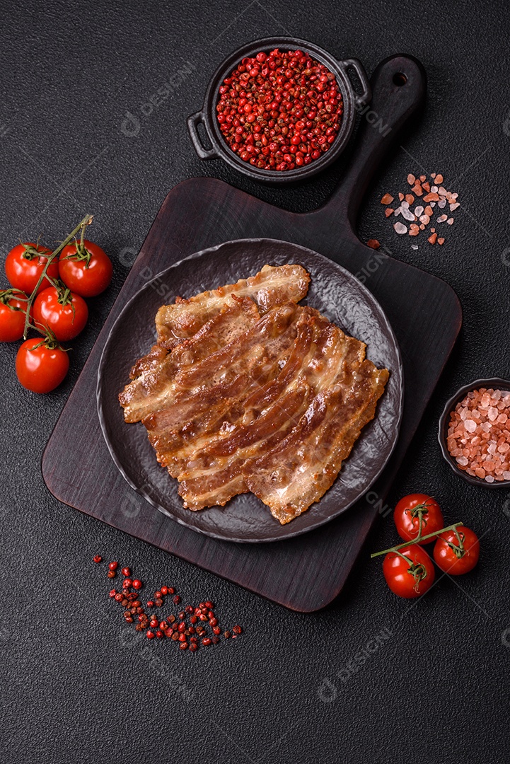 A imagem mostra toucinho frito em um prato, acompanhado de tomates-cereja e pimenta-rosa