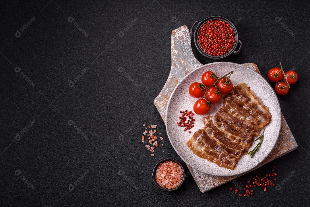 A imagem mostra toucinho frito em um prato, acompanhado de tomates-cereja e pimenta-rosa
