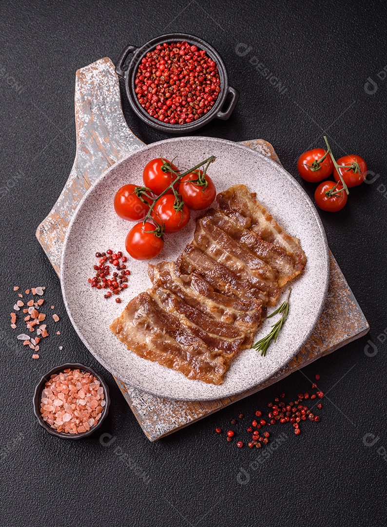 A imagem mostra toucinho frito em um prato, acompanhado de tomates-cereja e pimenta-rosa