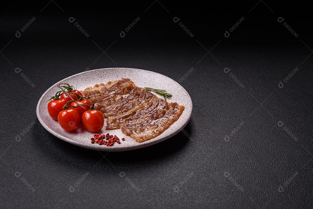 A imagem mostra toucinho frito em um prato, acompanhado de tomates-cereja e pimenta-rosa