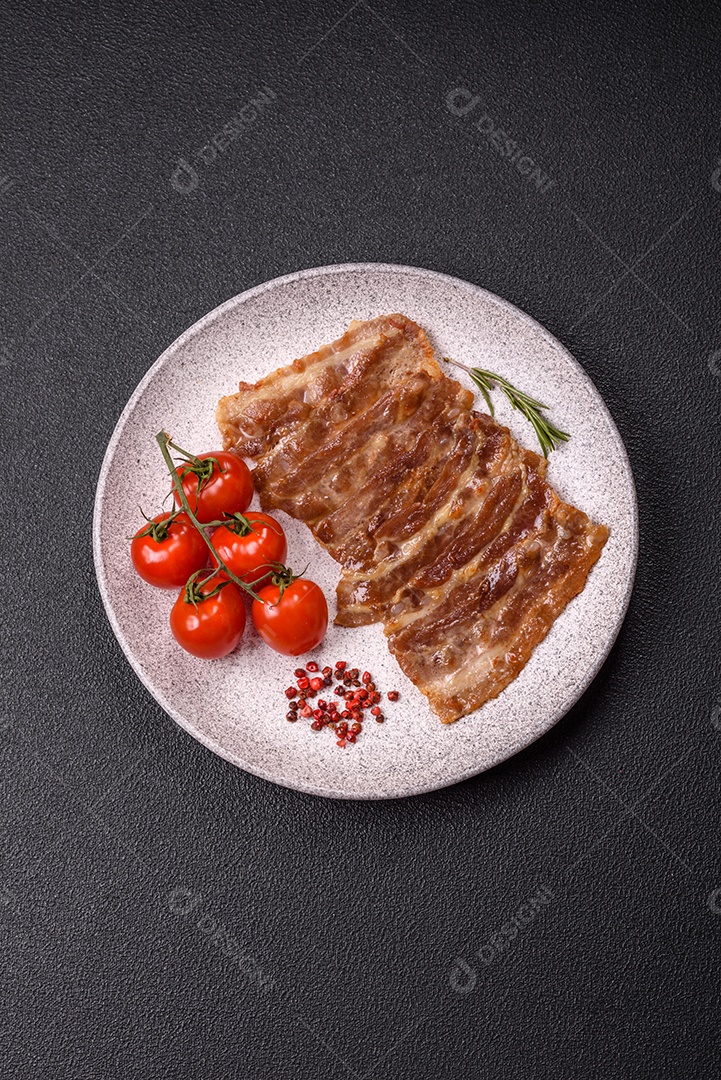A imagem mostra toucinho frito em um prato, acompanhado de tomates-cereja e pimenta-rosa