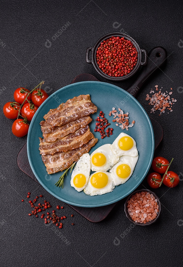 A imagem mostra um café da manhã farto com ovos fritos, bacon e tomates
