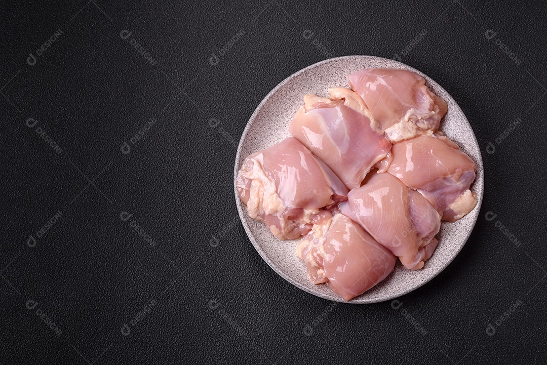 A imagem mostra sobrecoxas de frango cruas em um prato azul. A sobrecoxa é a parte superior da perna do frango