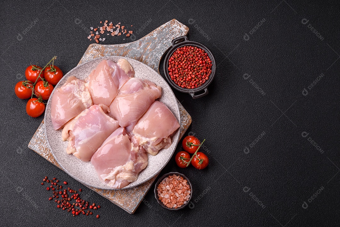 A imagem mostra sobrecoxas de frango cruas em um prato azul. A sobrecoxa é a parte superior da perna do frango