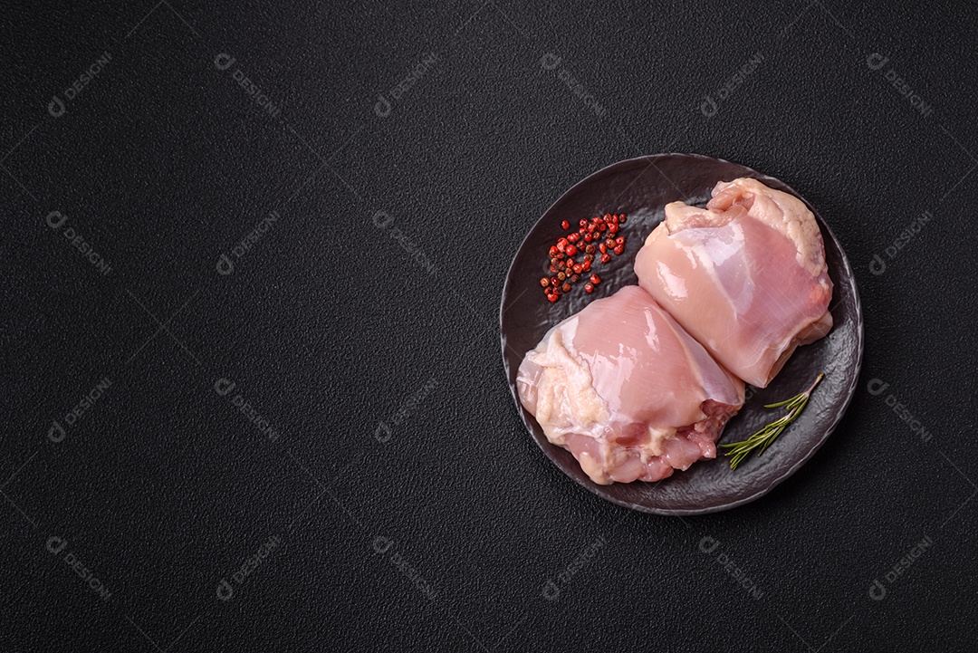 A imagem mostra sobrecoxas de frango cruas em um prato azul. A sobrecoxa é a parte superior da perna do frango