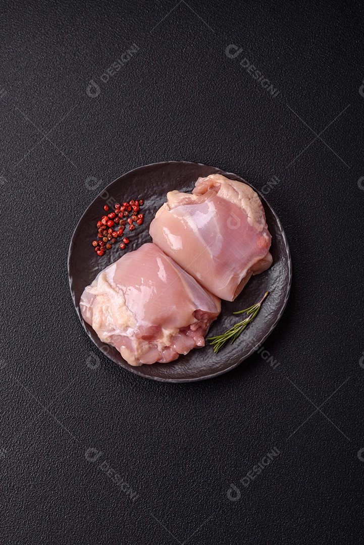 A imagem mostra sobrecoxas de frango cruas em um prato azul. A sobrecoxa é a parte superior da perna do frango