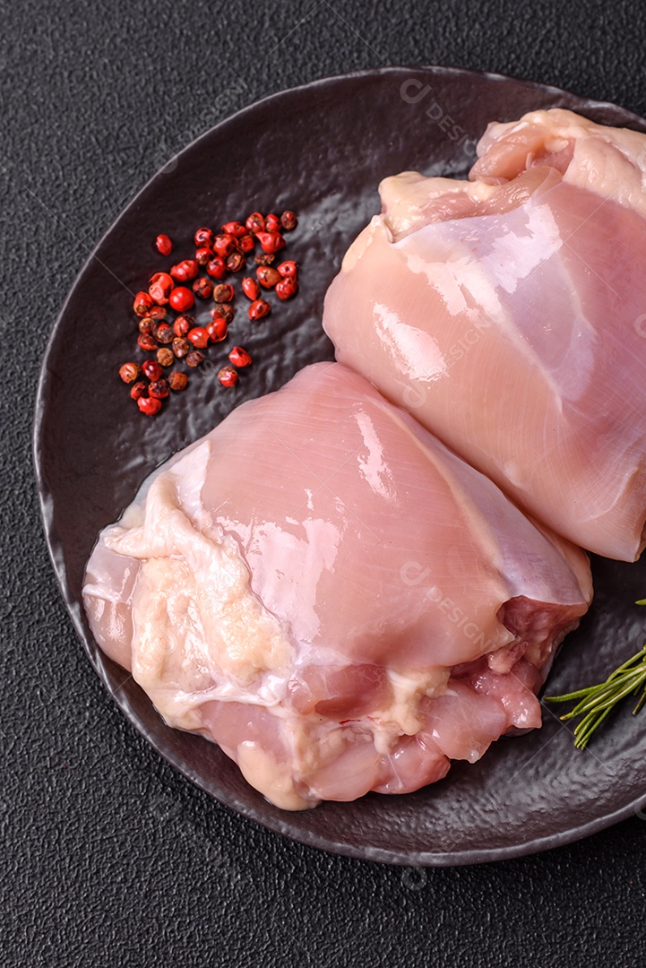 A imagem mostra sobrecoxas de frango cruas em um prato azul. A sobrecoxa é a parte superior da perna do frango