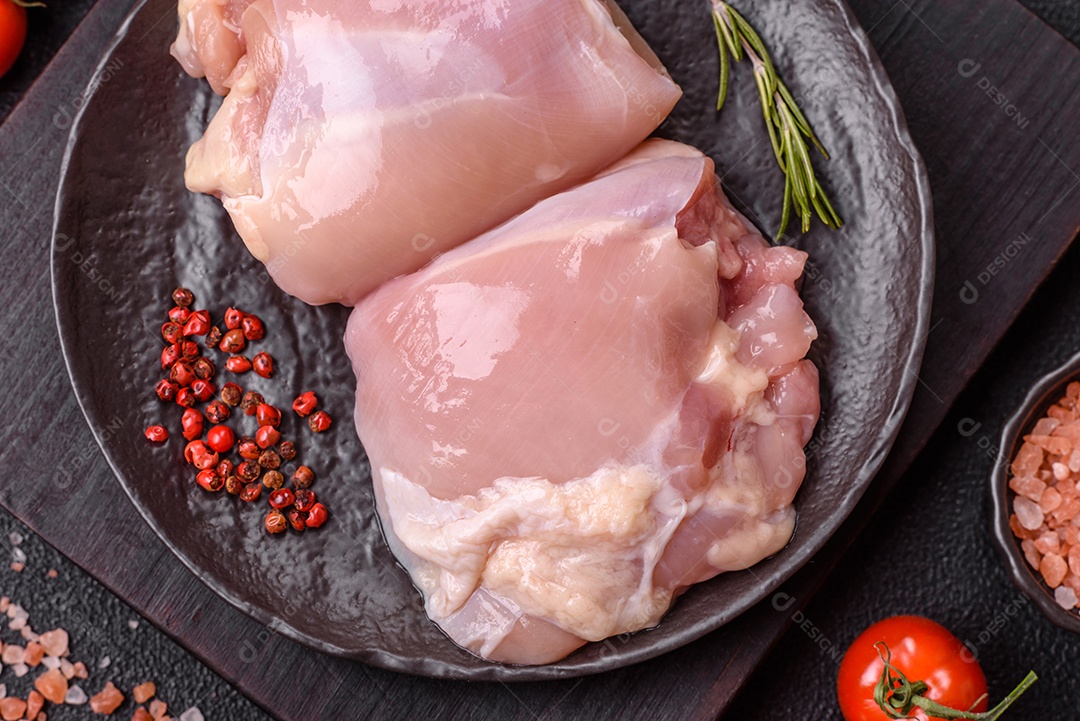 A imagem mostra sobrecoxas de frango cruas em um prato azul. A sobrecoxa é a parte superior da perna do frango