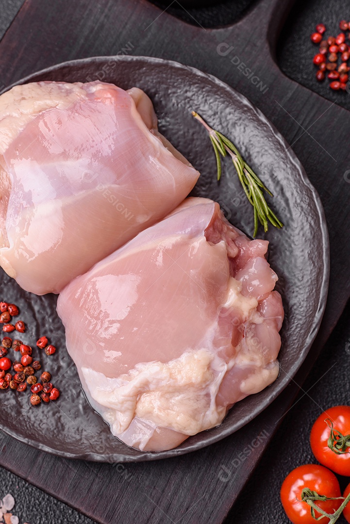 A imagem mostra sobrecoxas de frango cruas em um prato azul. A sobrecoxa é a parte superior da perna do frango