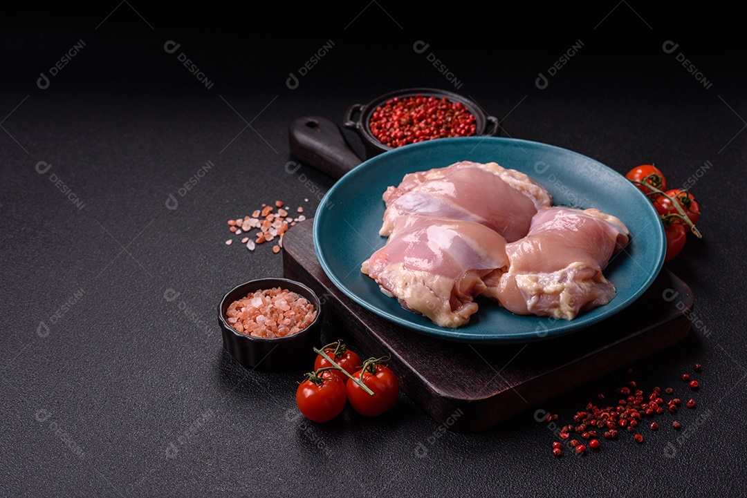 A imagem mostra sobrecoxas de frango cruas em um prato azul. A sobrecoxa é a parte superior da perna do frango