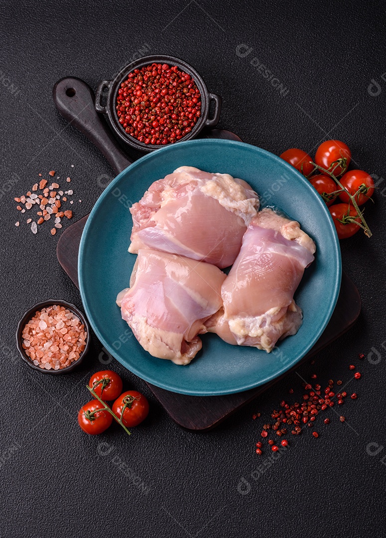 A imagem mostra sobrecoxas de frango cruas em um prato azul. A sobrecoxa é a parte superior da perna do frango