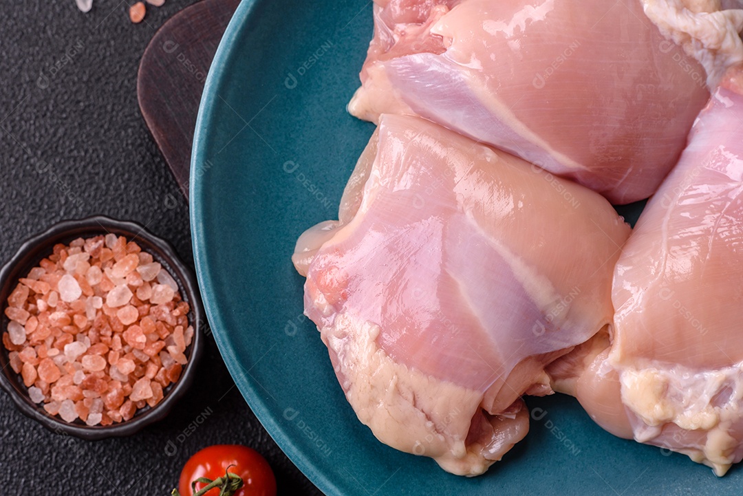 A imagem mostra sobrecoxas de frango cruas em um prato azul. A sobrecoxa é a parte superior da perna do frango