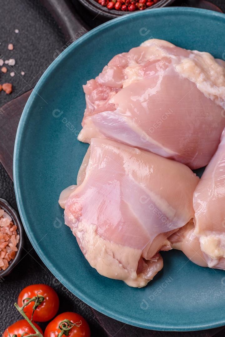 A imagem mostra sobrecoxas de frango cruas em um prato azul. A sobrecoxa é a parte superior da perna do frango