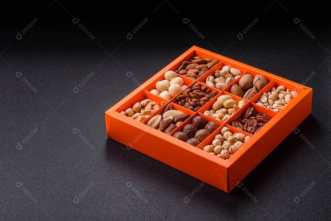 Imagem mostra uma variedade de oleaginosas, comumente chamadas de castanhas e nozes, em uma caixa dividida em compartimentos.