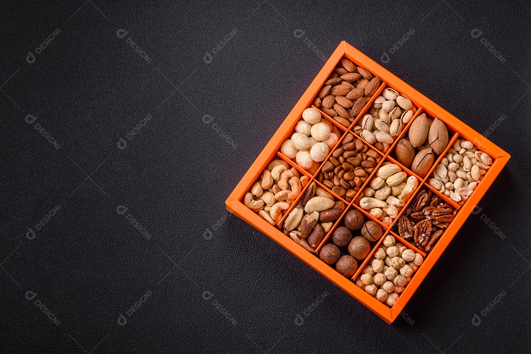 Imagem mostra uma variedade de oleaginosas, comumente chamadas de castanhas e nozes, em uma caixa dividida em compartimentos.