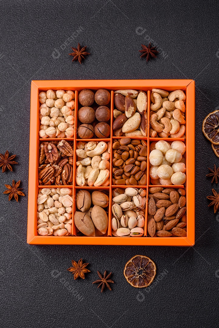 Imagem mostra uma variedade de oleaginosas, comumente chamadas de castanhas e nozes, em uma caixa dividida em compartimentos.