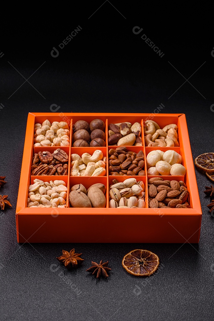 Imagem mostra uma variedade de oleaginosas, comumente chamadas de castanhas e nozes, em uma caixa dividida em compartimentos. Comida